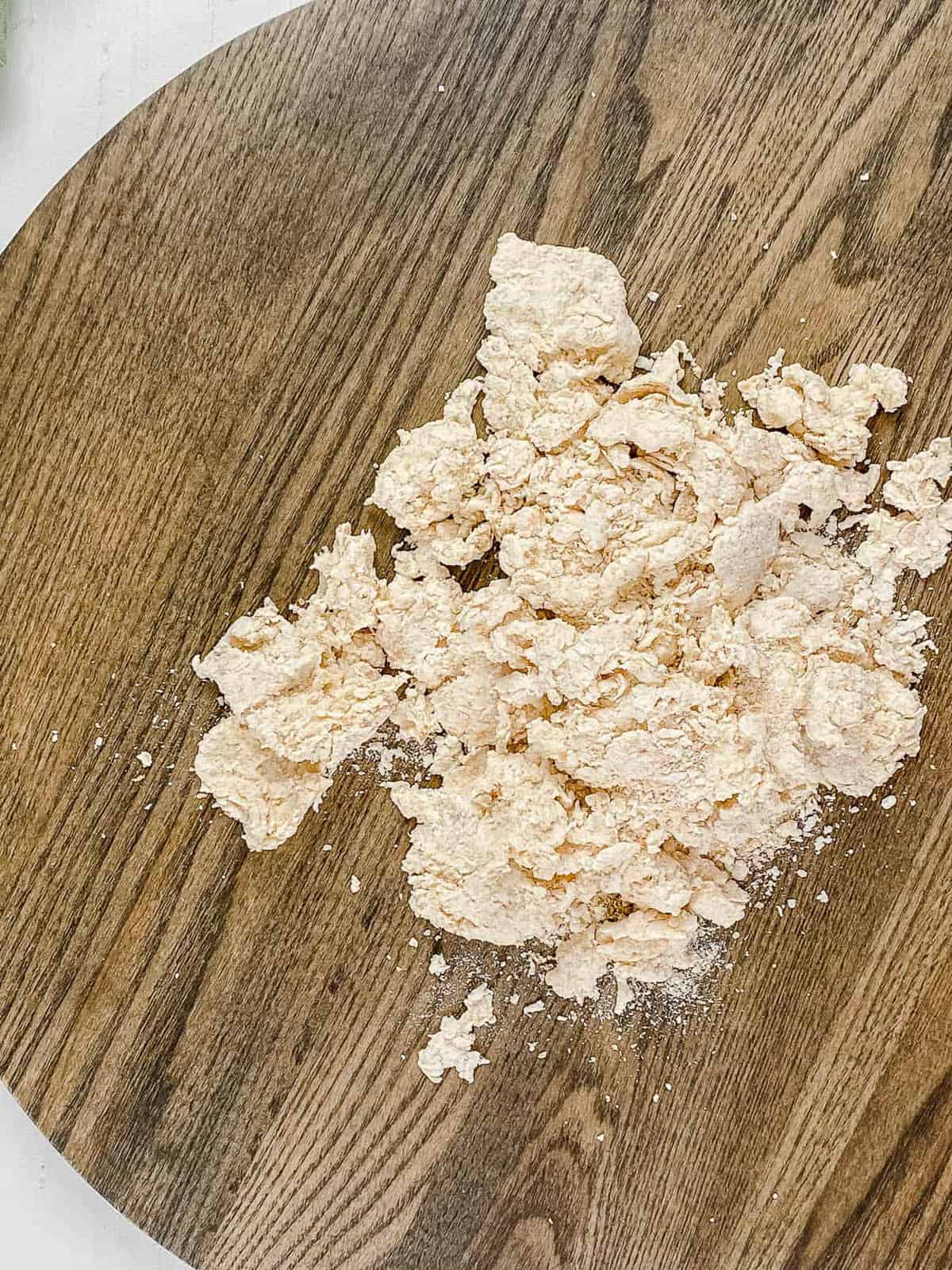The low calorie pizza dough on a wooden cutting board before kneading.