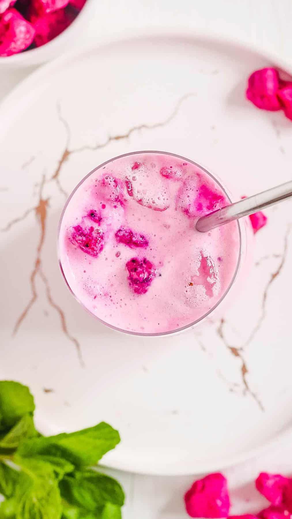 Overhead shot of a glass of dragonfruit drink with a metal spoon!