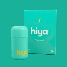 Bottle of Hiya probiotics against a green background.