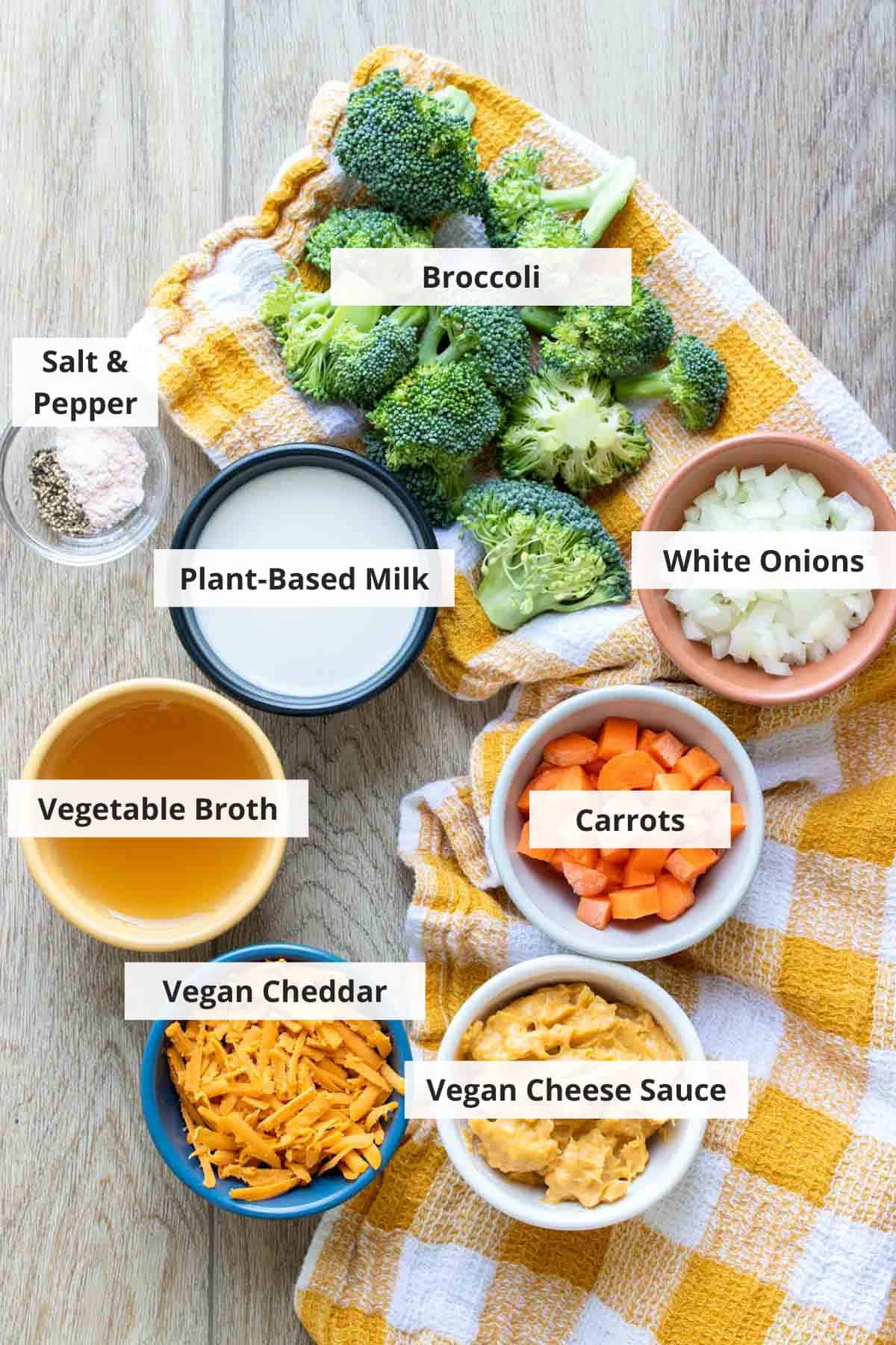 Ingredients for vegan broccoli cheddar soup on a wood countertop.