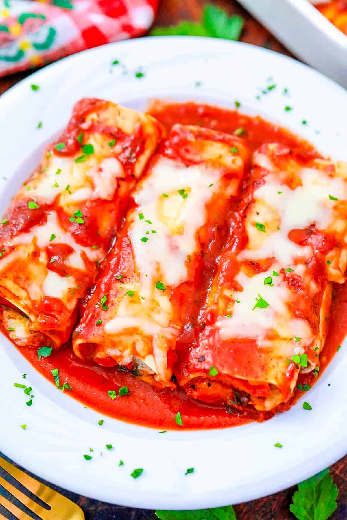 Vegetarian pasta rolls on a white plate.