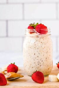 Peanut butter overnight oats in a mason jar with strawberries and bananas.