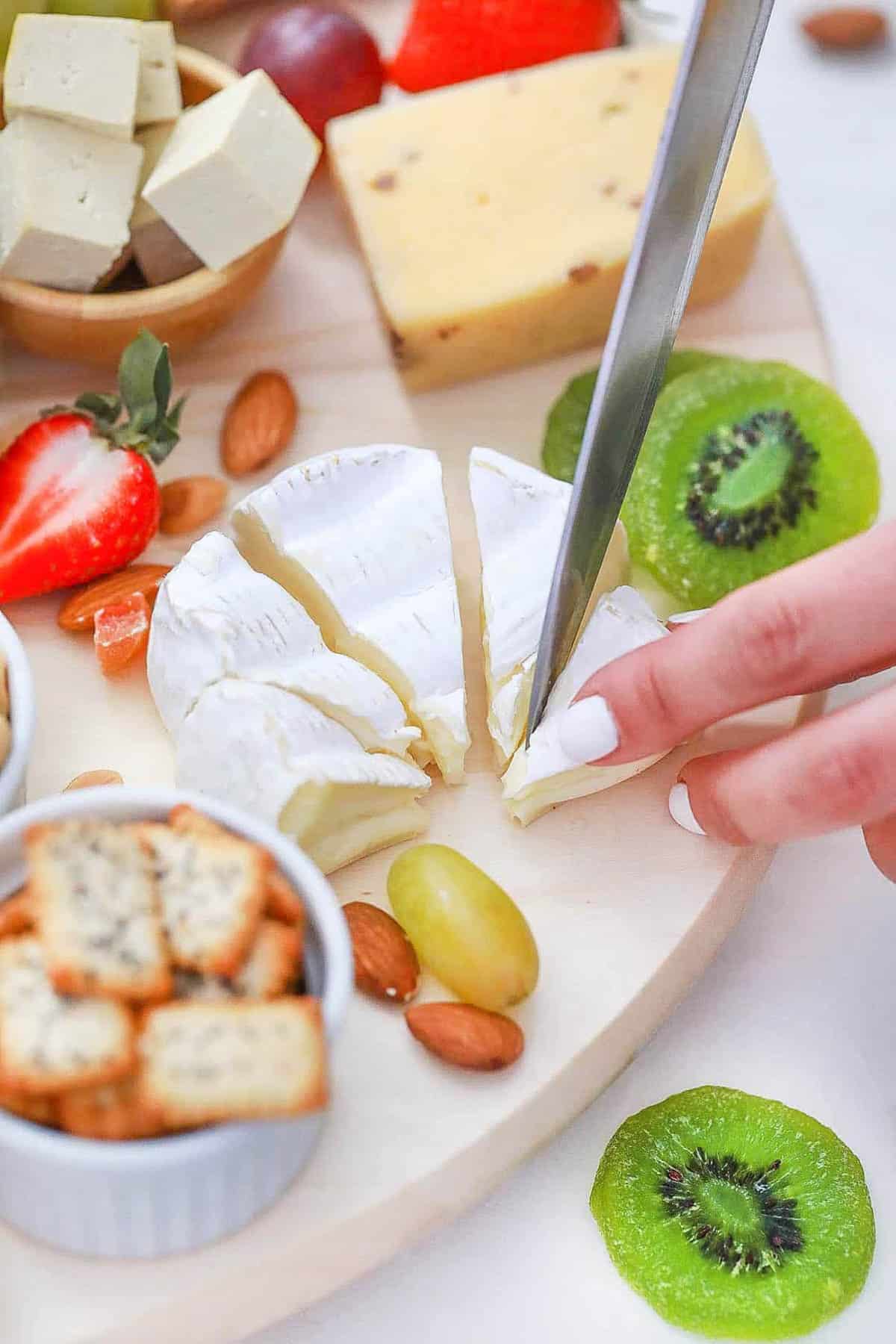 Sliced brie on a vegetarian charcuterie board.