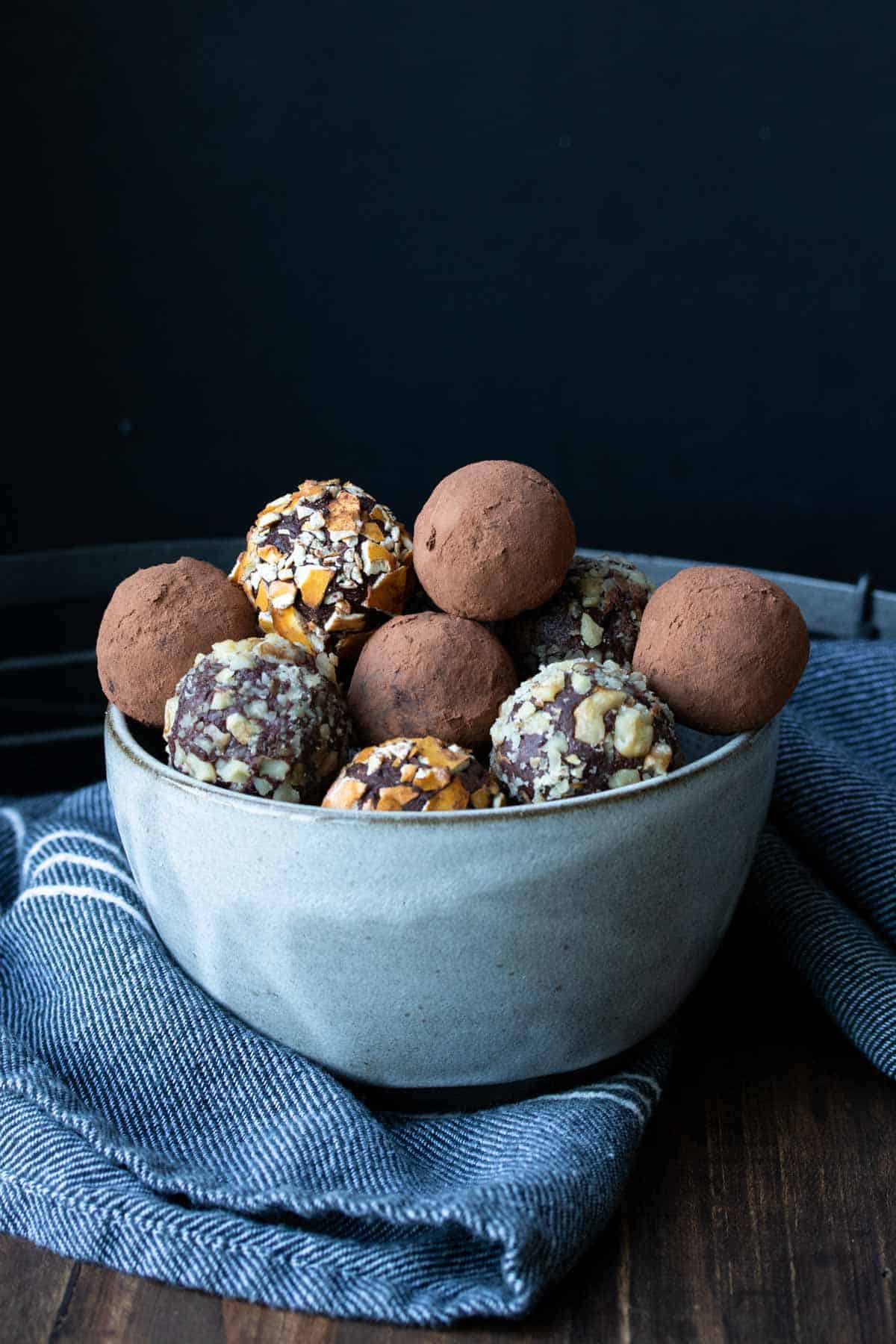 A pile of chocolate truffles in a grey bowl.