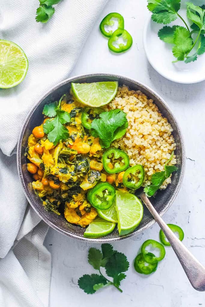 Easy vegan Thai green curry recipe served with quinoa in a black bowl.