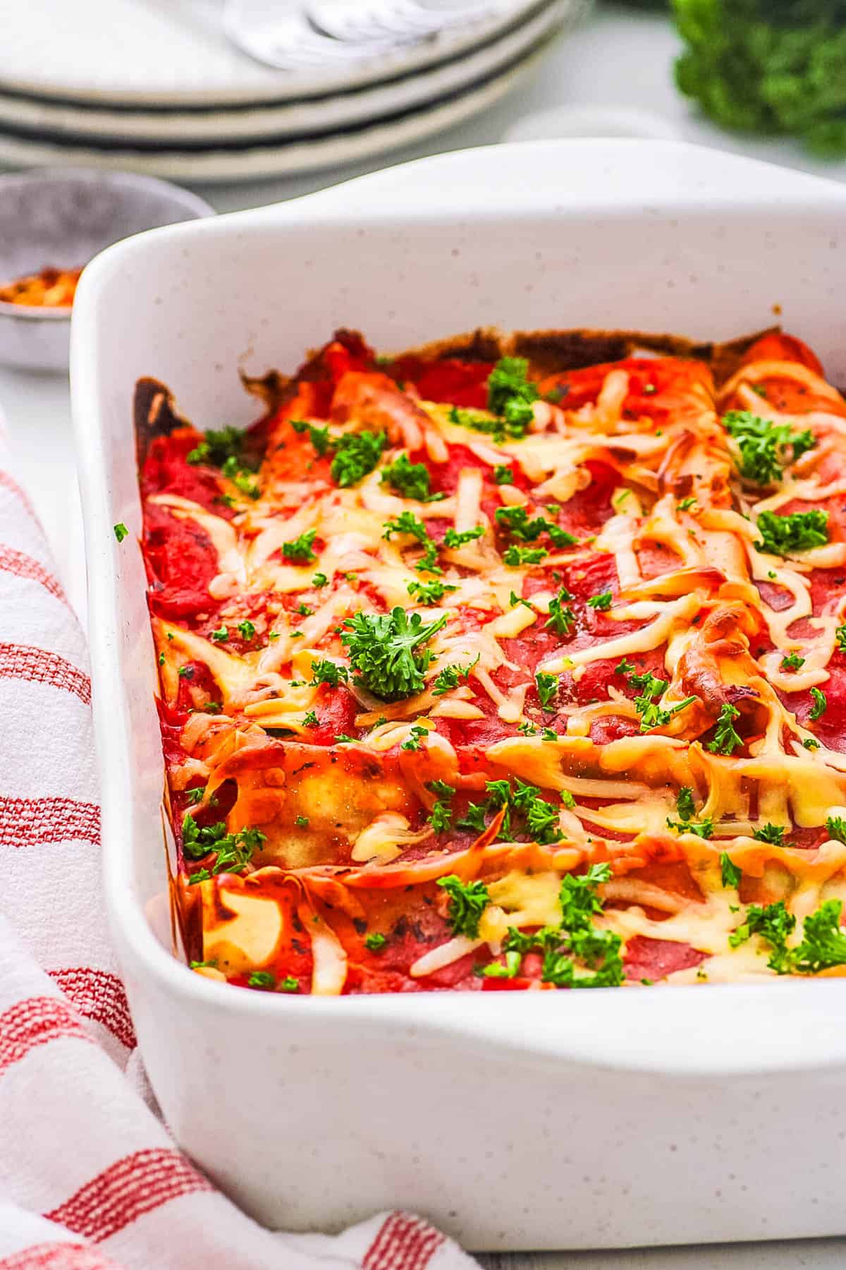 Vegetarian pasta rolls in a casserole dish, topped with fresh herbs.