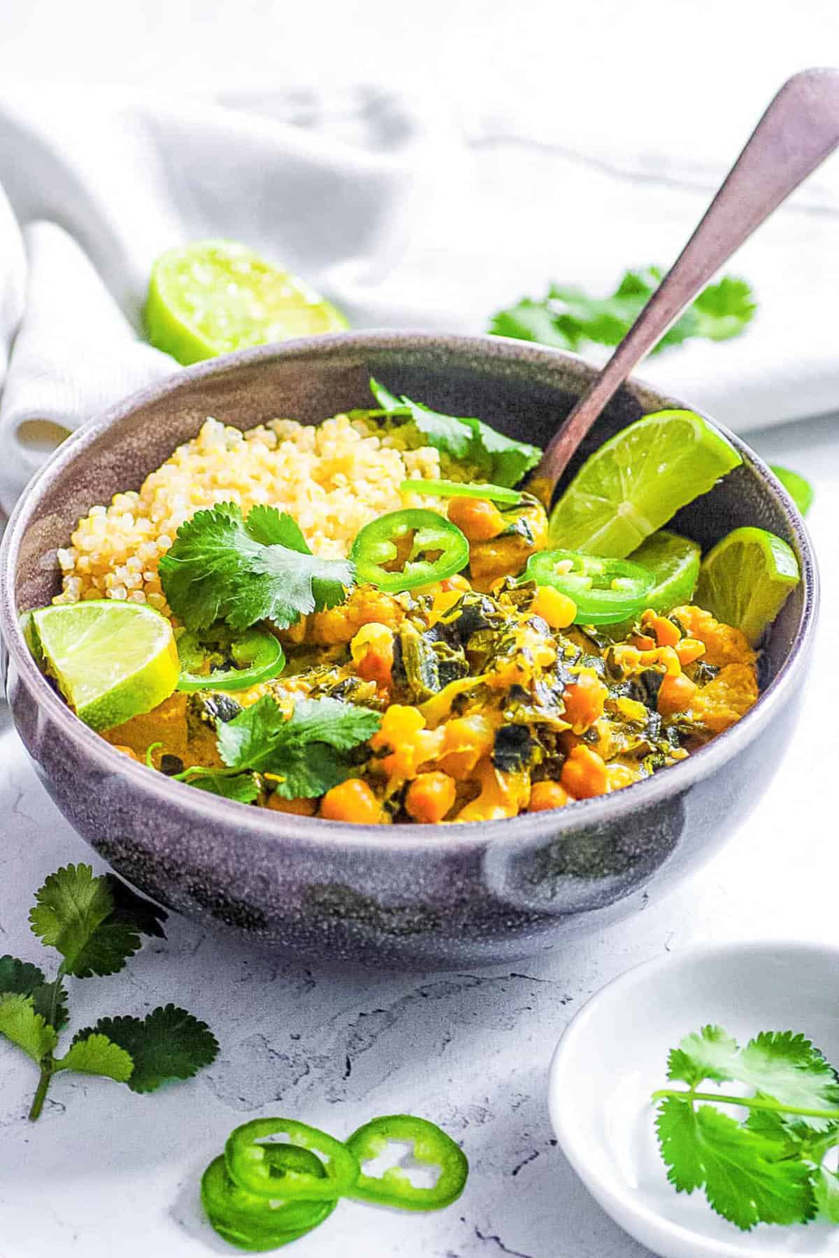 Easy vegan Thai green curry recipe served with quinoa in a black bowl.