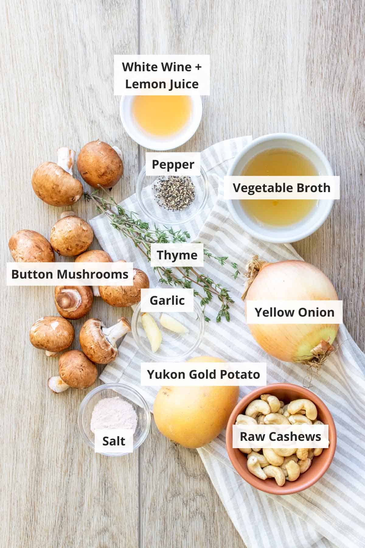 Ingredients for vegan cream of mushroom soup on a wood countertop.