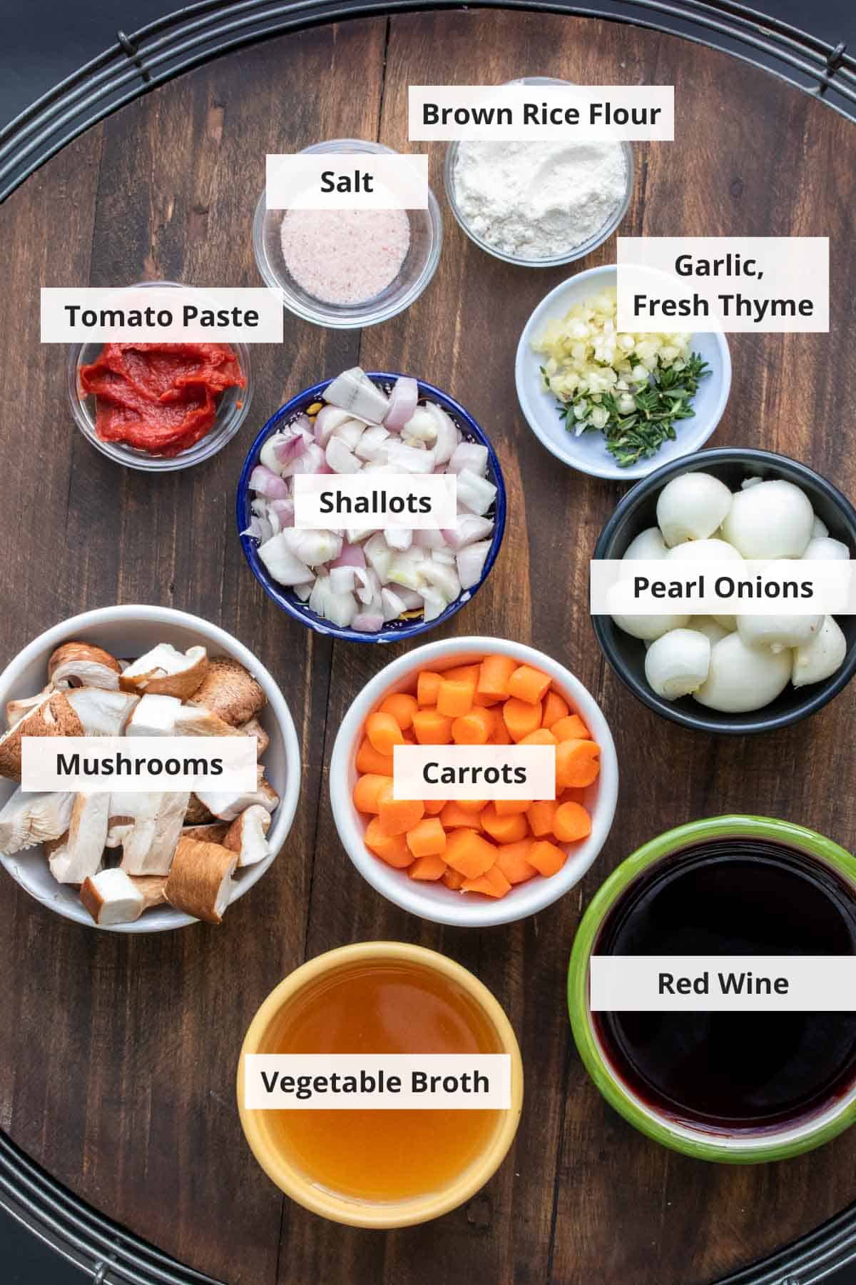 Ingredients for vegan mushroom bourguignon on a wood background.