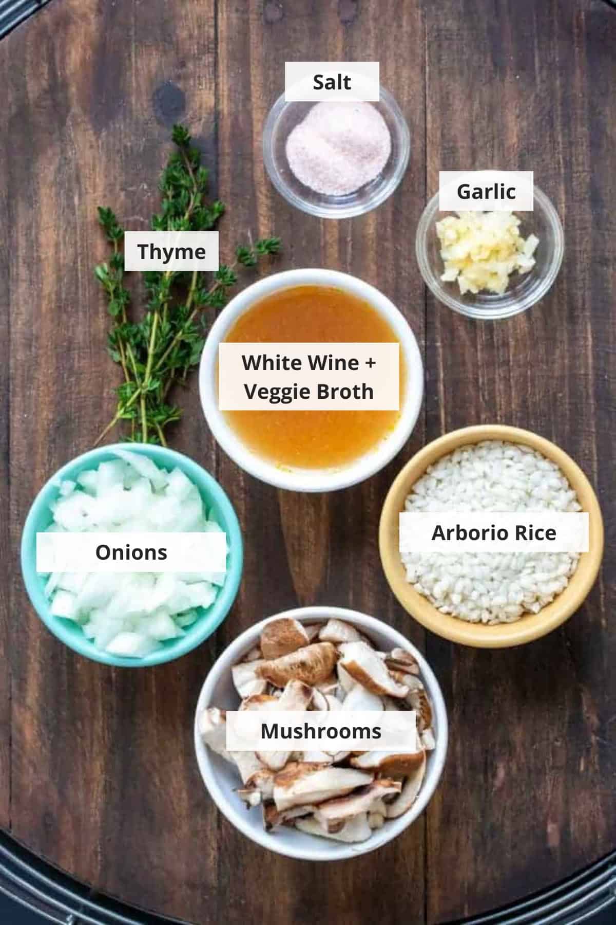 Ingredients for vegan mushroom risotto recipe on a wood background.