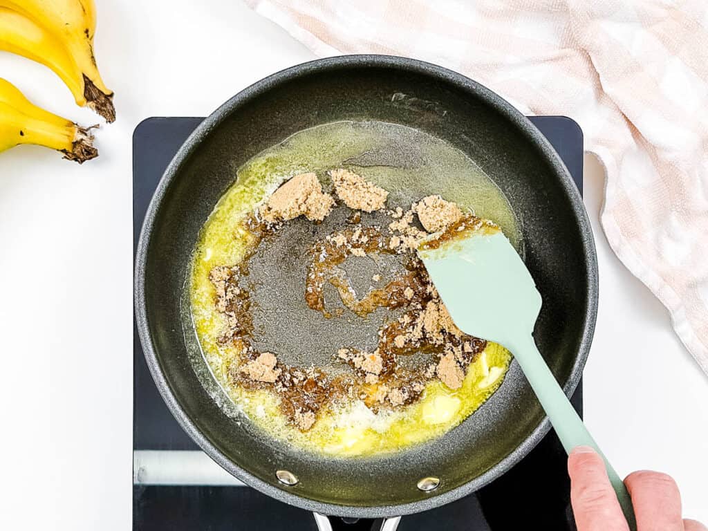 Brown sugar and butter sauteeing in a pan.