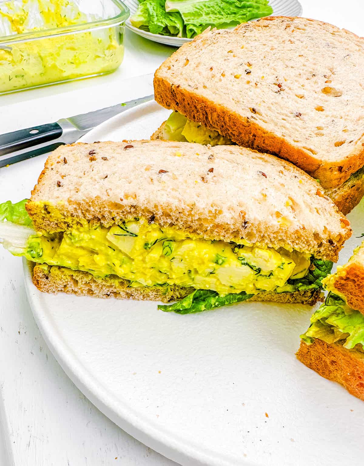 Eggless egg salad sandwich on a white plate.