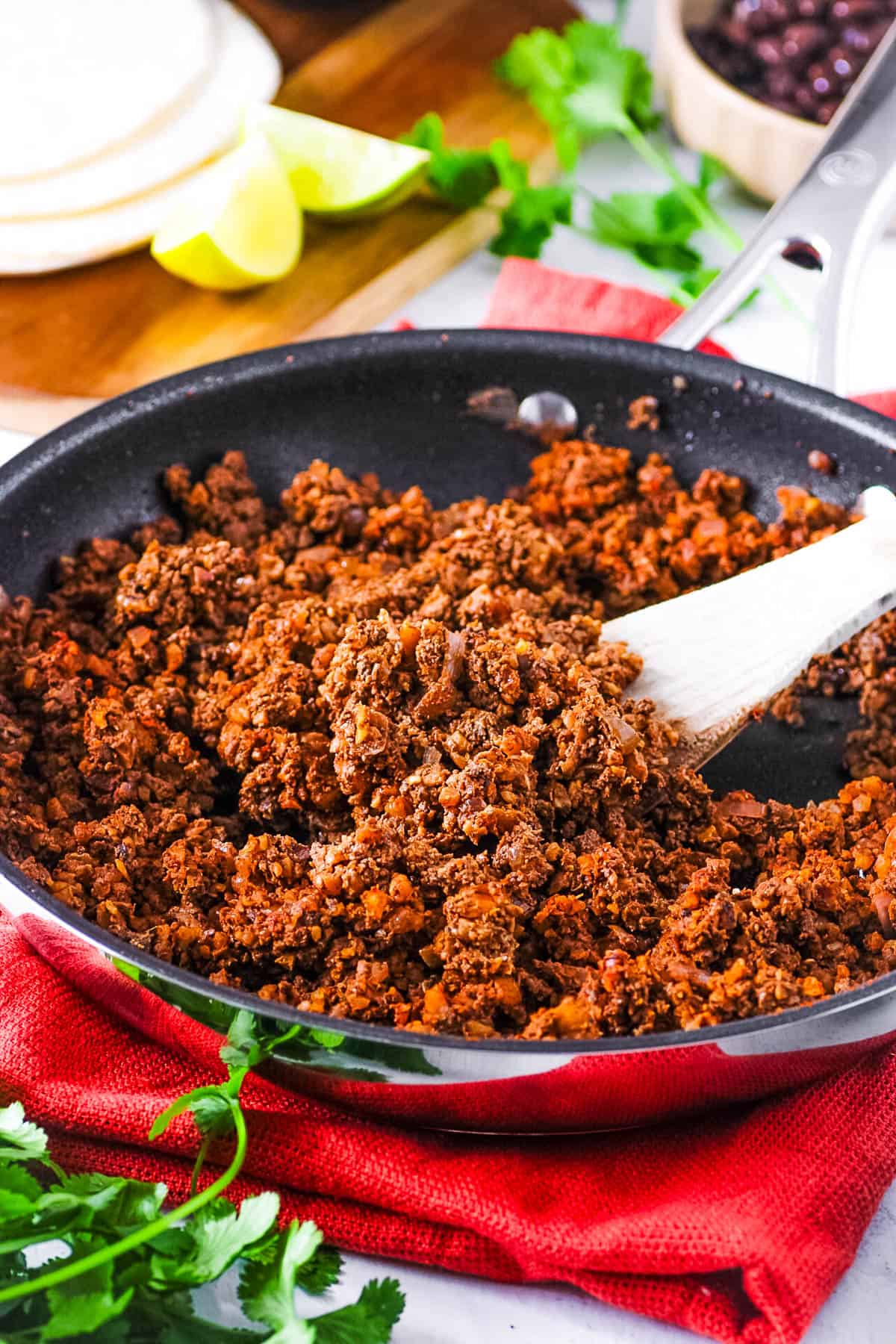 Vegan walnut taco meat, served in a large skillet with a wooden spoon.