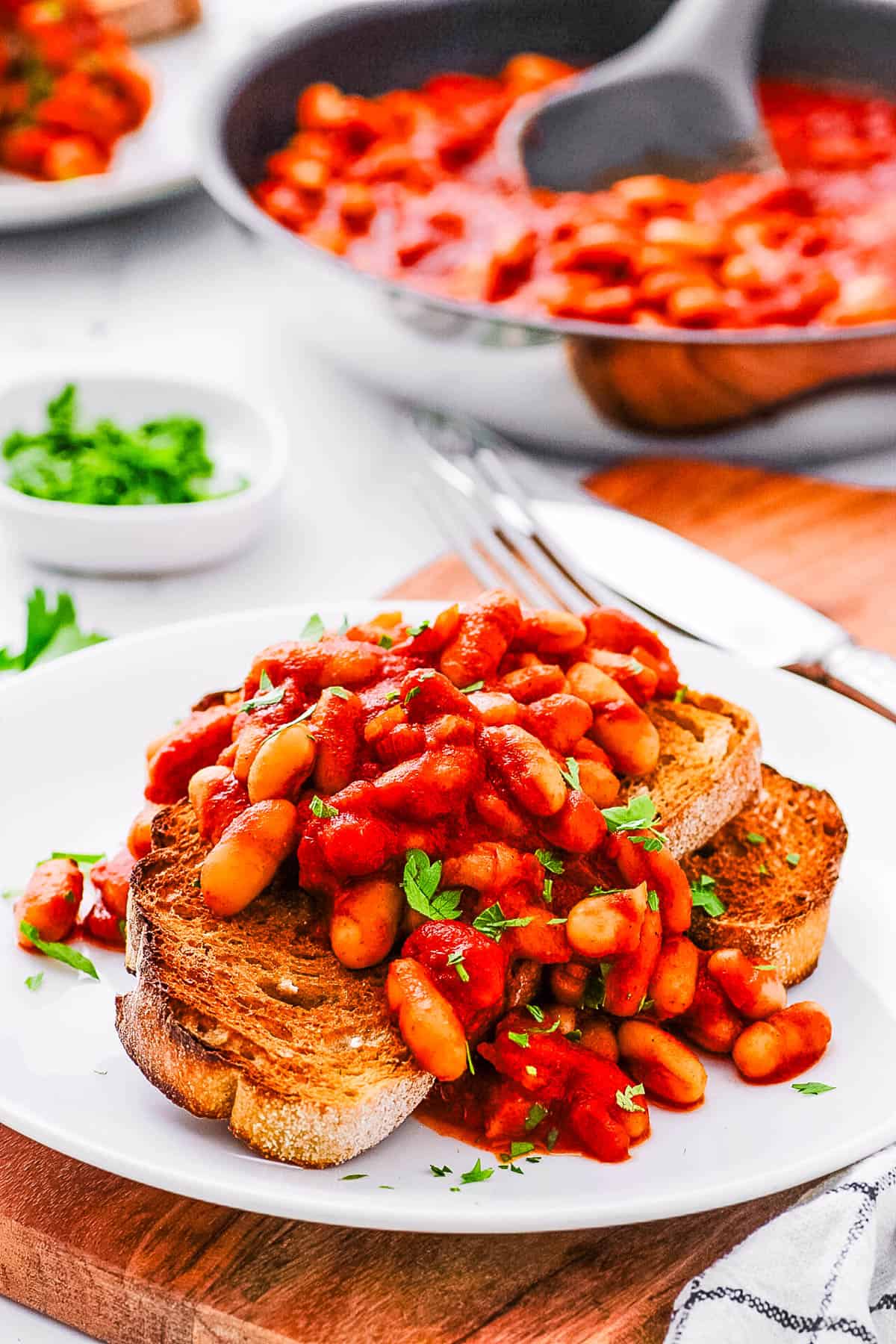 Vegetarian baked beans on toast served on a white plate.