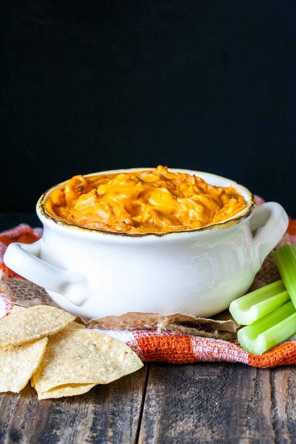 White soup bowl filled with baked vegan buffalo dip.