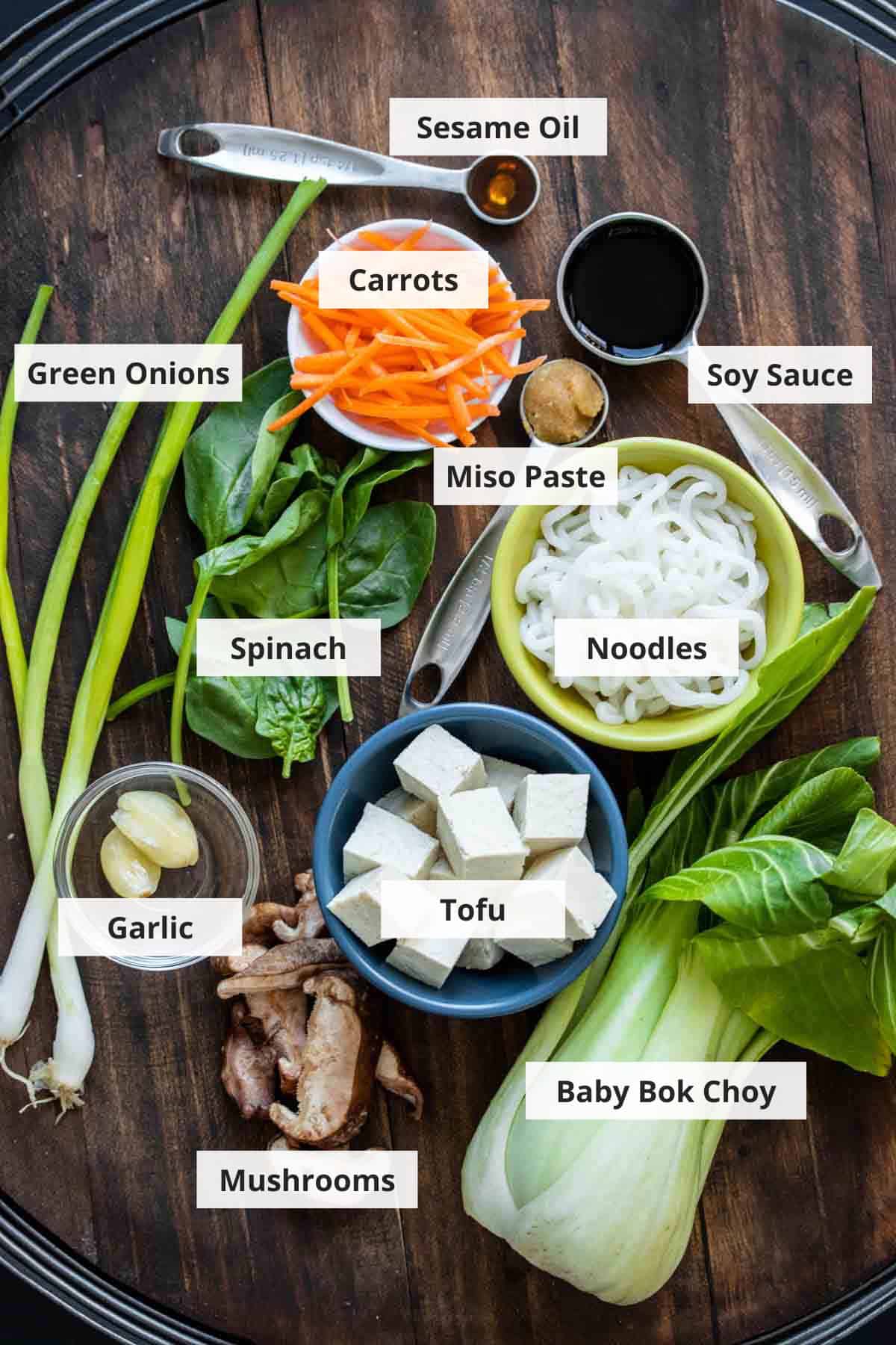 Ingredients for vegan miso soup recipe on a wood background.