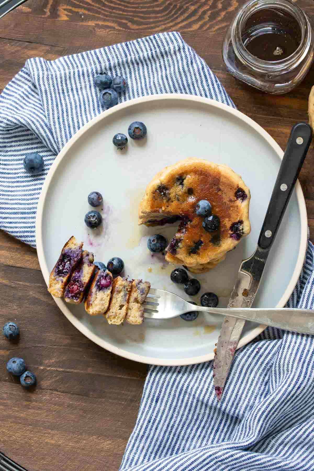 Top view of vegan blueberry pancakes with a cut out bite next to it.