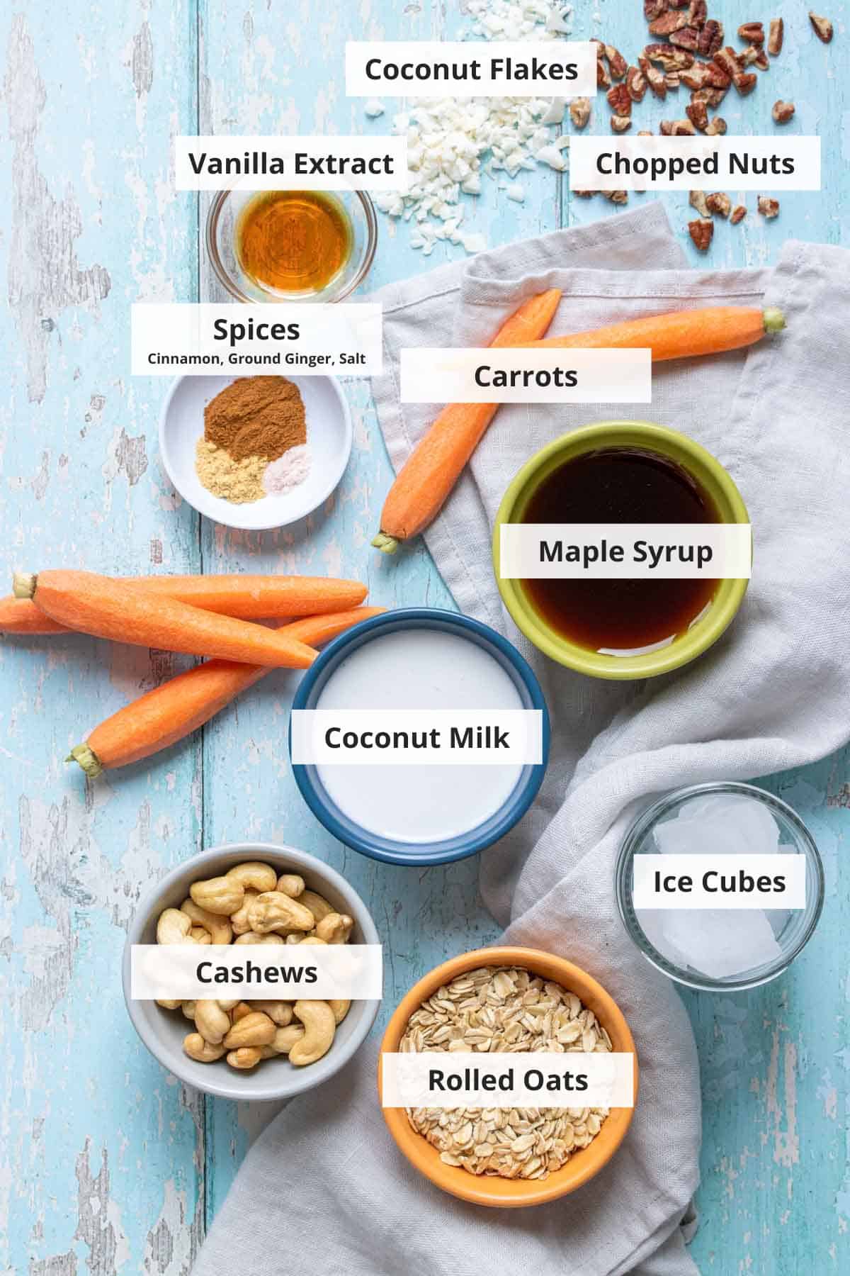 Ingredients for vegan carrot cake smoothie on a blue wood background.
