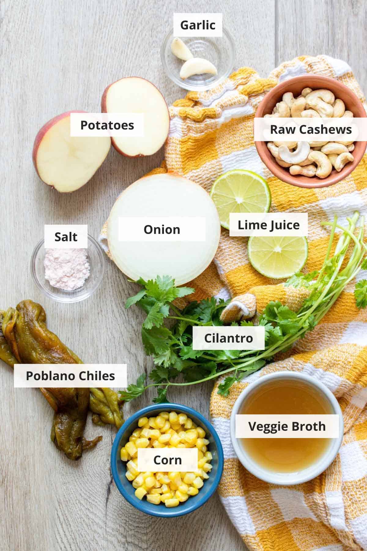 Ingredients for vegan roasted poblano corn chowder on a wood countertop.