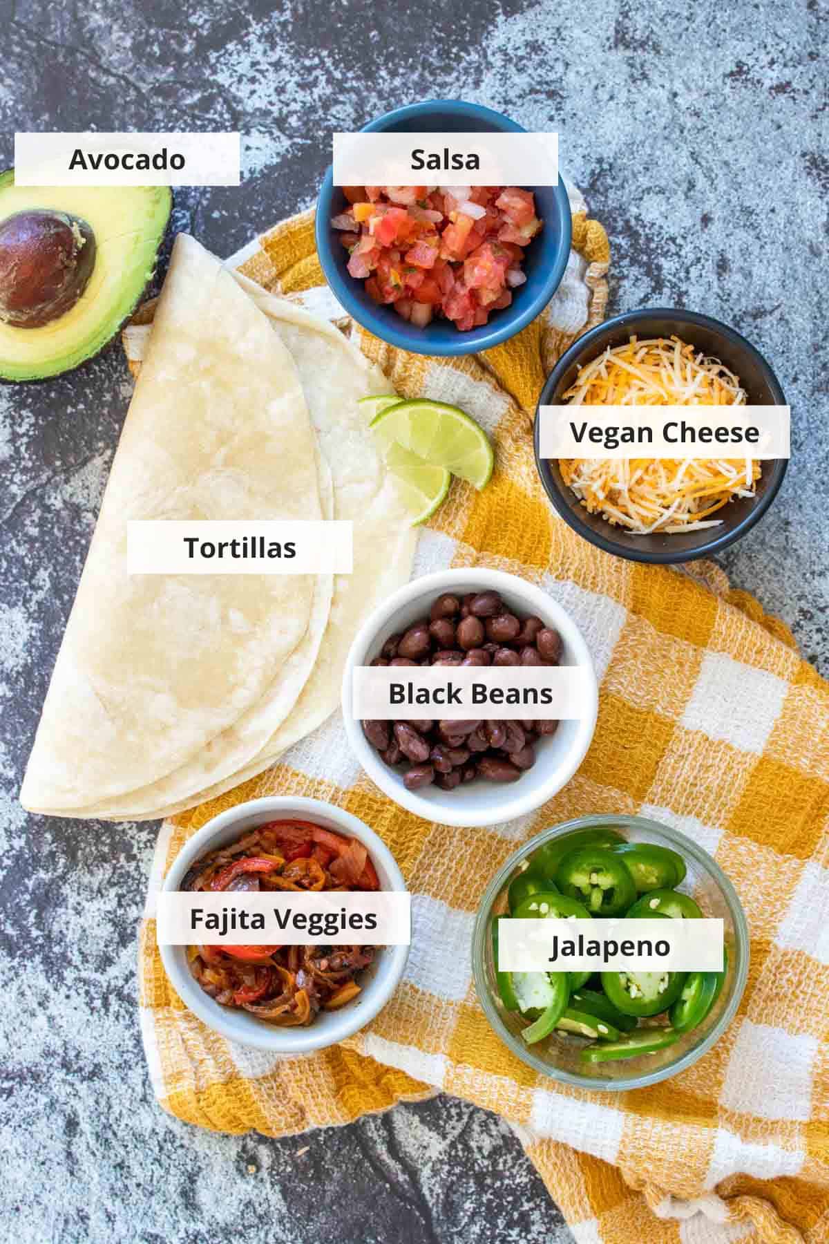 Ingredients for vegan black bean quesadillas on a marble countertop.