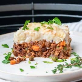 A piece of vegan cottage pie on a white plate.