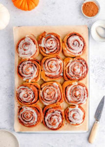 Healthy cinnamon rolls with low sugar icing, served on a large sheet of parchment paper.