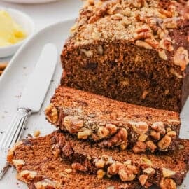 Vegan protein banana bread, sliced and served on a white plate.