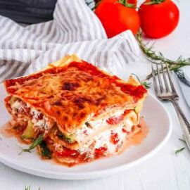 A piece of healthy vegetarian lasagna, served on a white plate.