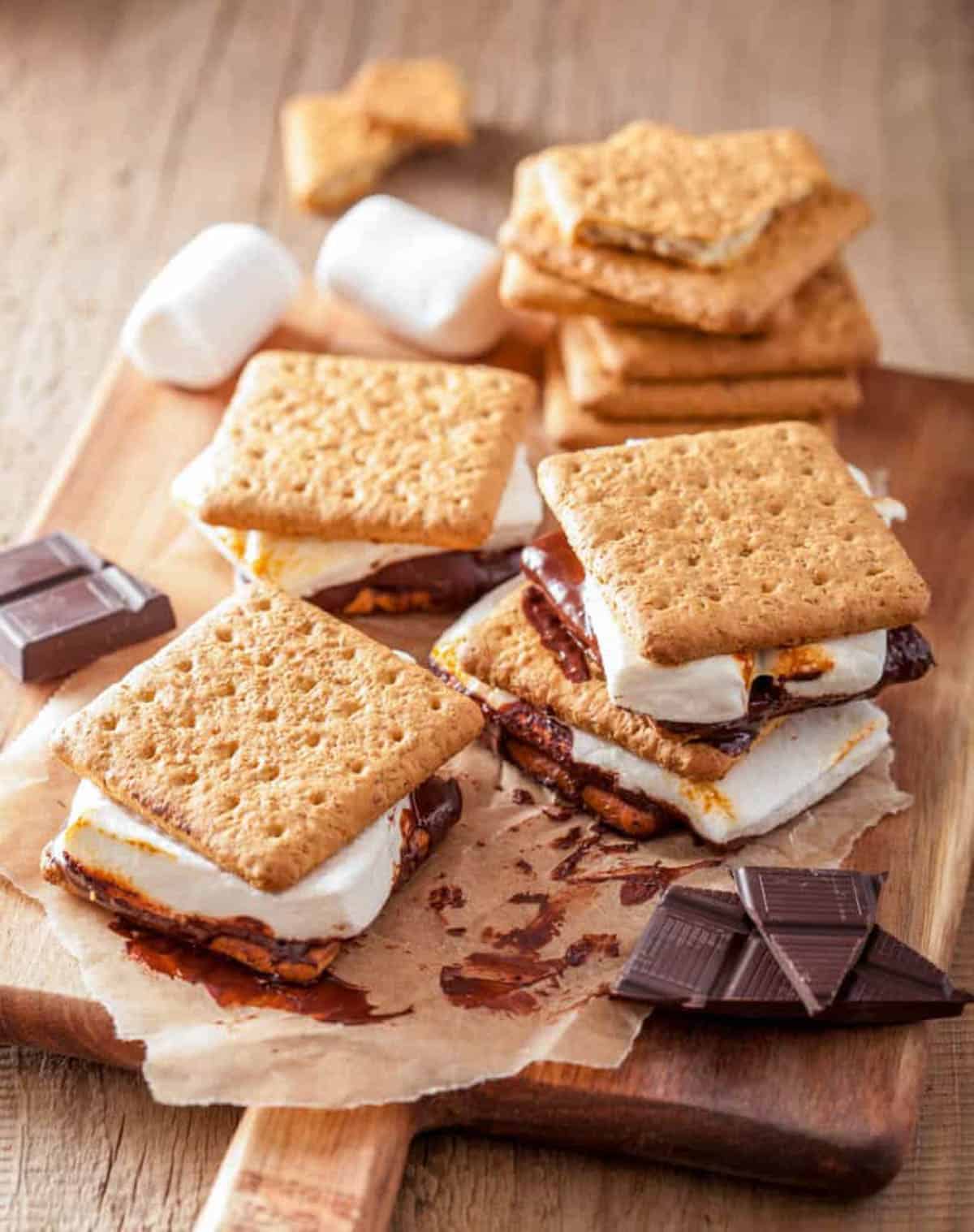 Vegan s'mores prepared and placed on top of a wooden cutting board.