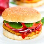 Pinto bean burgers served on a whole wheat bun on a white plate.