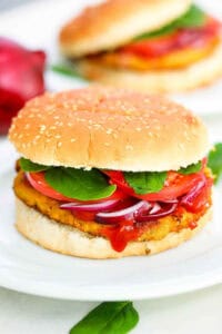 Pinto bean burgers served on a whole wheat bun on a white plate.