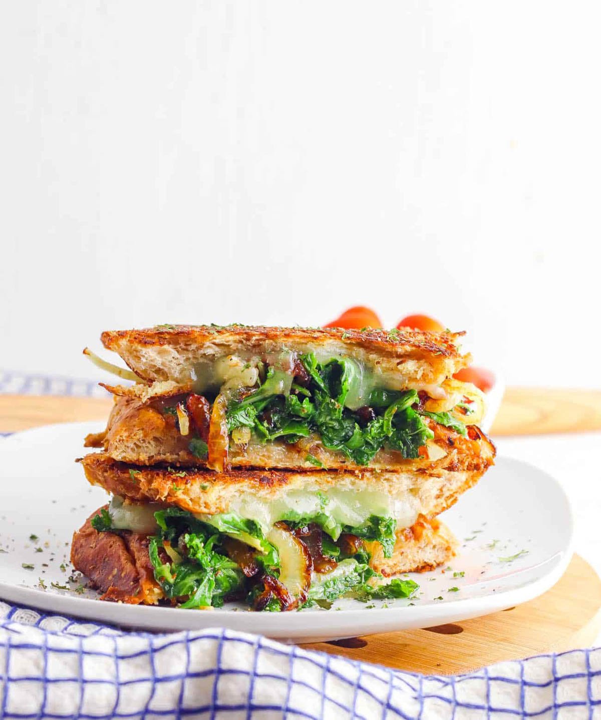 Veggie panini with kale and caramelized onion served on a white plate.