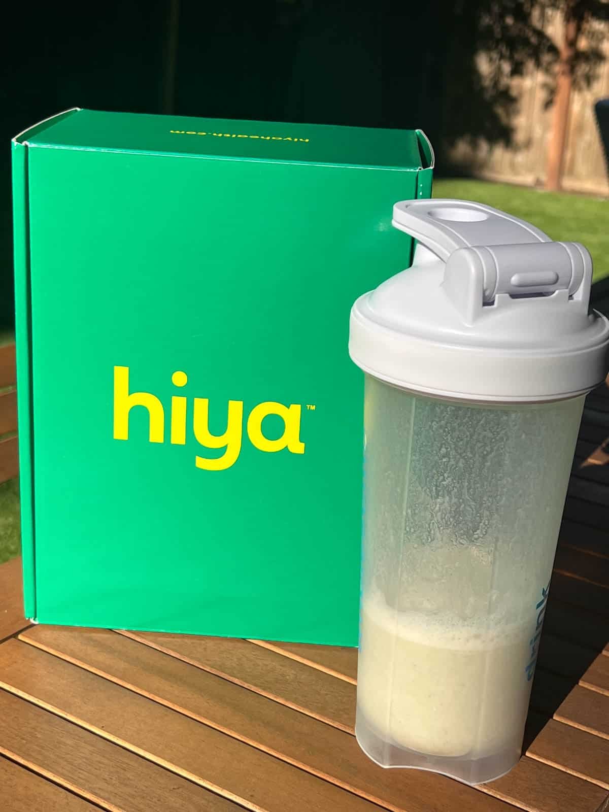 Hiya Greens box next to a shaker bottle with prepared Hiya greens.