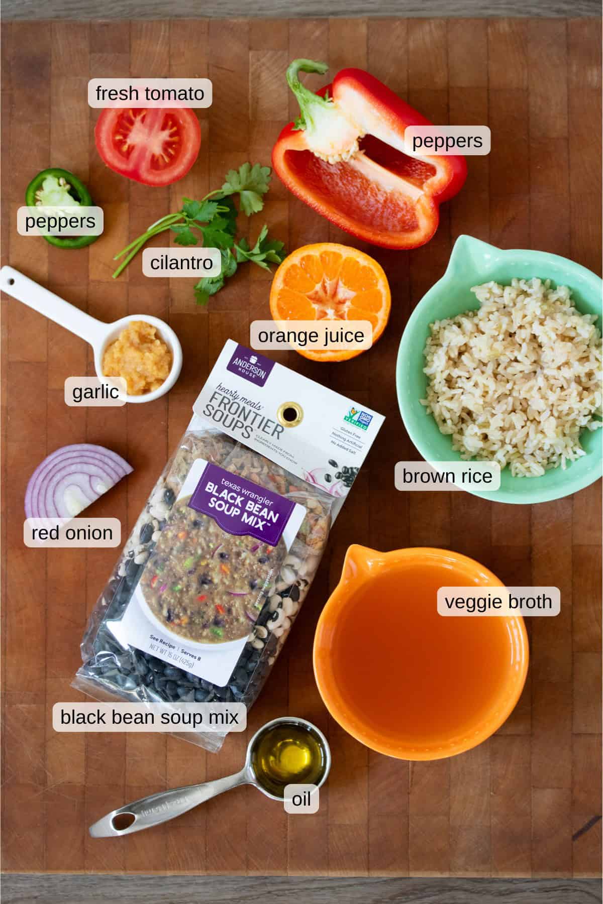 Top view of ingredients for a black bean and rice salad on a wooden background.