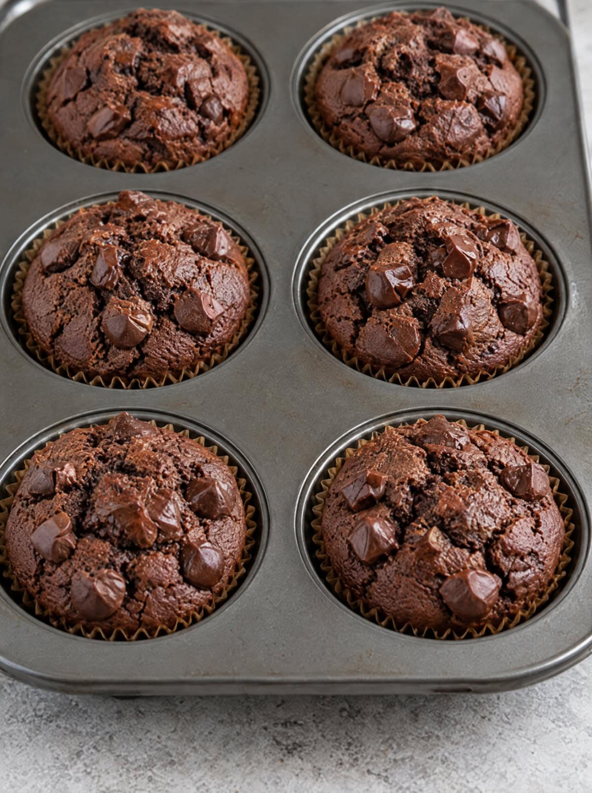 Chocolate sweet potato muffins in a muffin tin, fresh out of the oven.